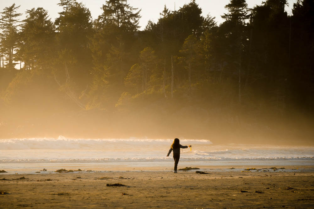 Young child playing on a misty beach