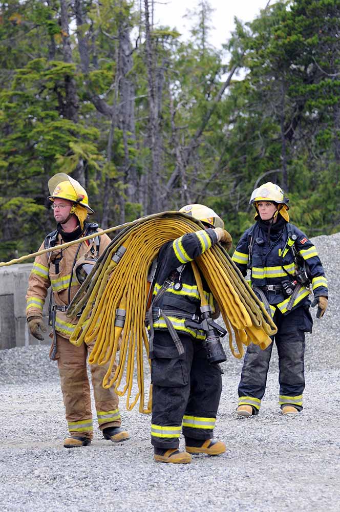 Firefighters in action carrying hose