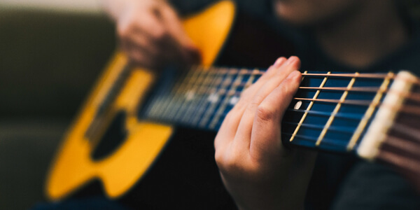 Detail of person playing acoustic guitar